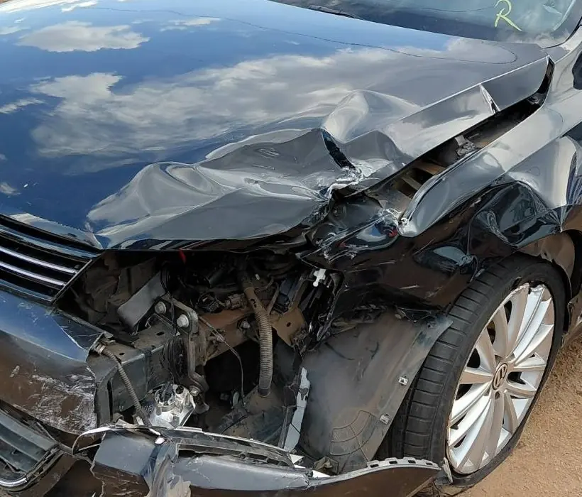 Frente esquerda de um Volkswagen Jetta 2014 após colisão: capô dobrado, para-lama esmagado e farol destruído